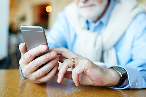 Modern senior man texting in smartphone