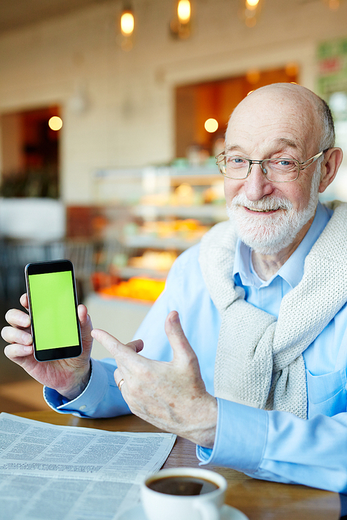 Aged man pointing at touchscreen of smartphone in his hand