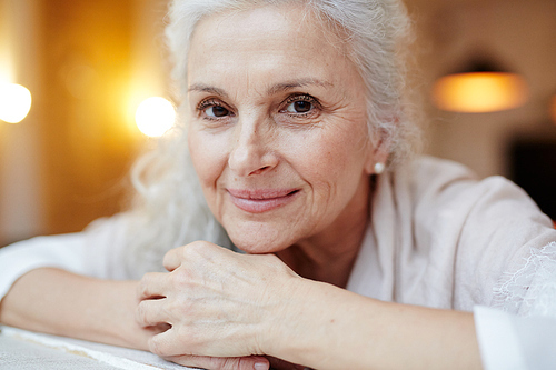 Happy grey-haired female smiling at camera