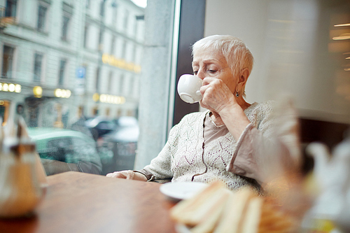 Senior female drinking coffee in cafe