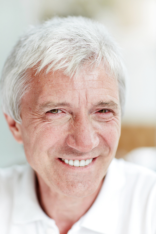 Senior grey-haired man with toothy smile 