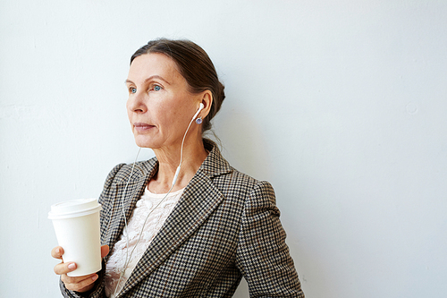 Aged female with hot drink listening to music or lecture
