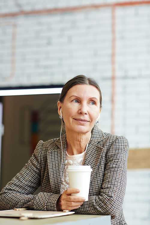 Happy female with earphones relaxing in cafe