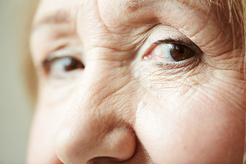 Extreme close-up shot of deep dark brown eyes with wrinkles around them 