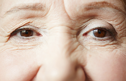 Smiling dark brown eyes of elderly woman , extreme close-up shot