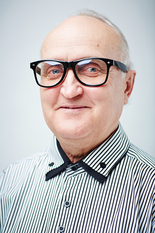 Close-up portrait of charming old gentleman in striped shirt and eyeglasses  and smiling cheerfully