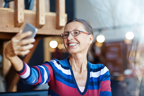 Smiley mature woman making her selfie