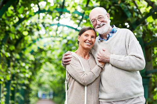Devoted seniors in casualwear standing in embrace outdoors