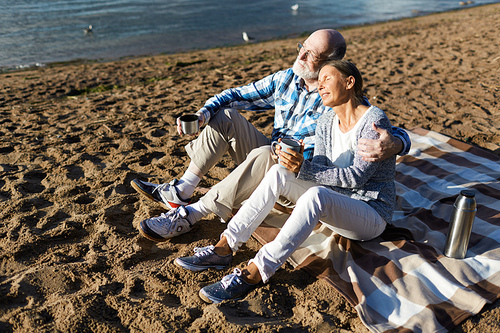 Retired couple taking pleasure in summer evening on the beach