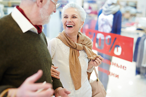 Laughing senior female talking to her husband during shopping