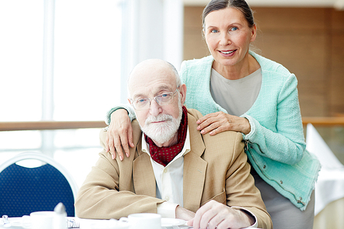 Affectionate retired couple sitting in restaurant