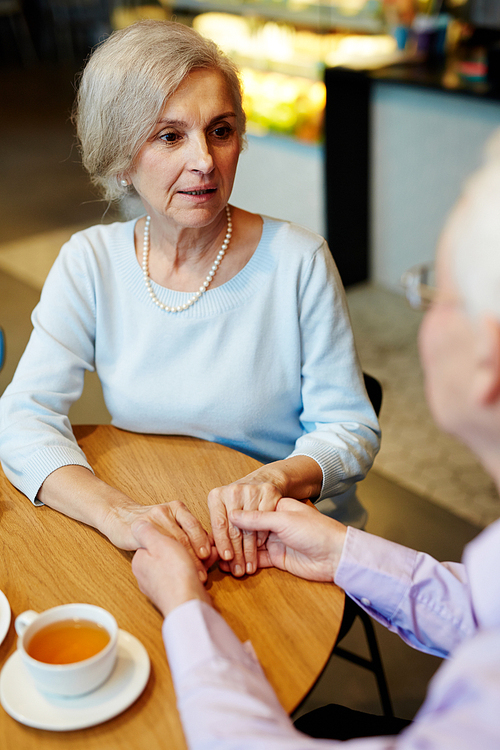 Senior female talking to her husband while holding his hands