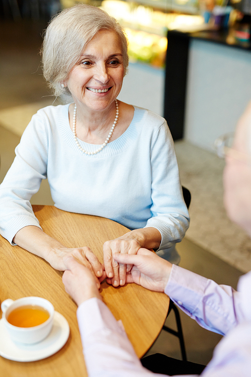 Happy senior woman talking to her husband by tea