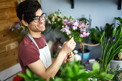 Handsome young man with flower working as florist
