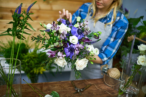 Young woman arranging floral bouquet