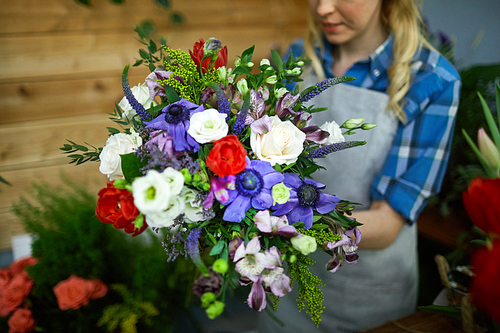Woman arranging multi-floral bouquet for selling