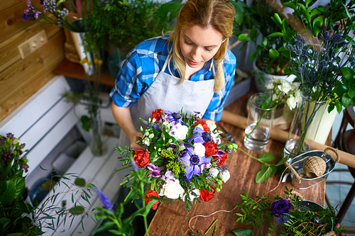Top view of florist with bouquet by her workplace