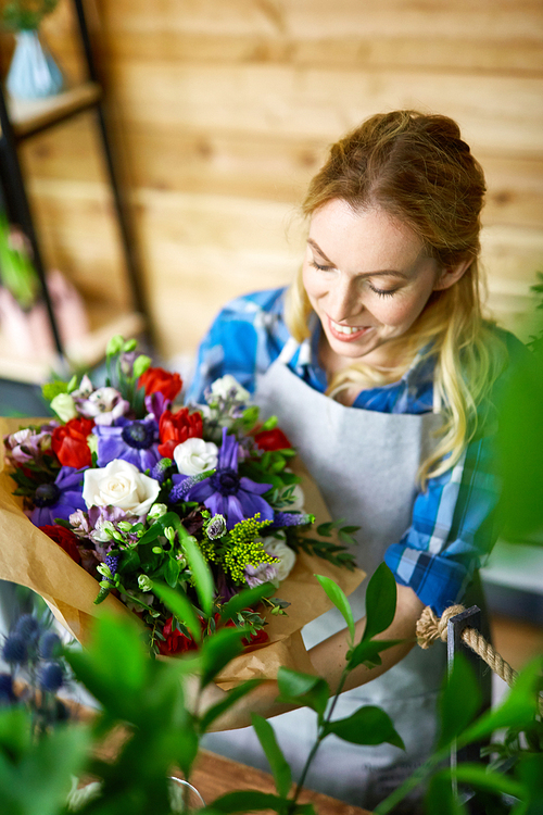 Self-employed florist holding arranged bouquet