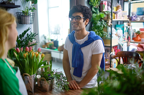 Young man going to buy flowers for his girlfriend in flower-shop