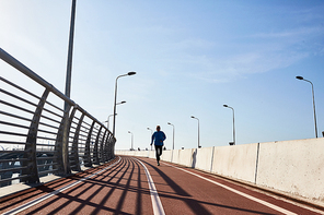 Contemporary sportsman training on cycling road with nobody around