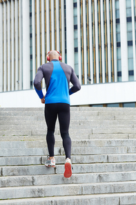 Young man jogging upwards the staircase