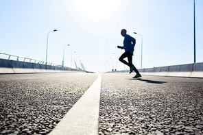 Sportsman crossing urban road during morning workout outdoors