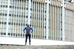 Young athlete standing against modern building