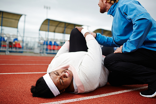 Persistent sport instructor encouraging young female with overweight working out harder