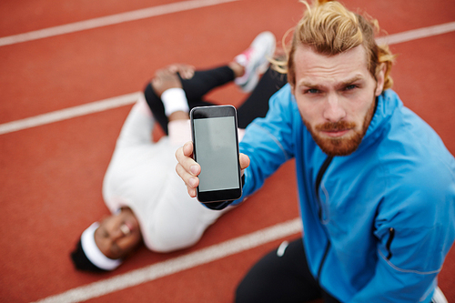 Trainer of obese exercising woman showing smartphone with blank display