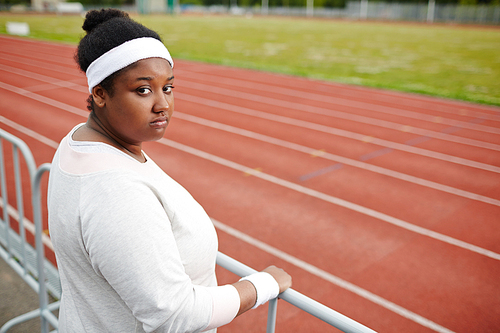 Plus-sized woman in activewear  during workout on stadium
