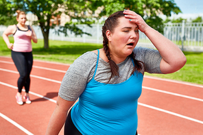 Exhausted runner touching her head with funny facial expression