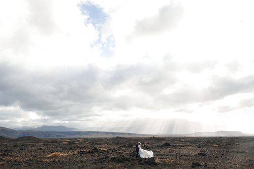 Married couple standing close to one another under cloudy sky of Iceland