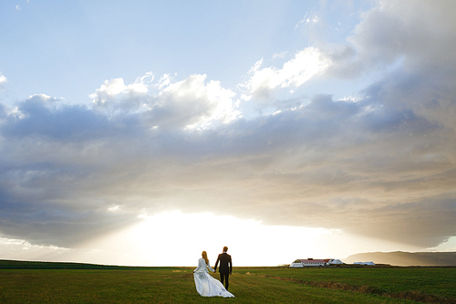 Rear view of romantic couple walking towards sun shone horizon