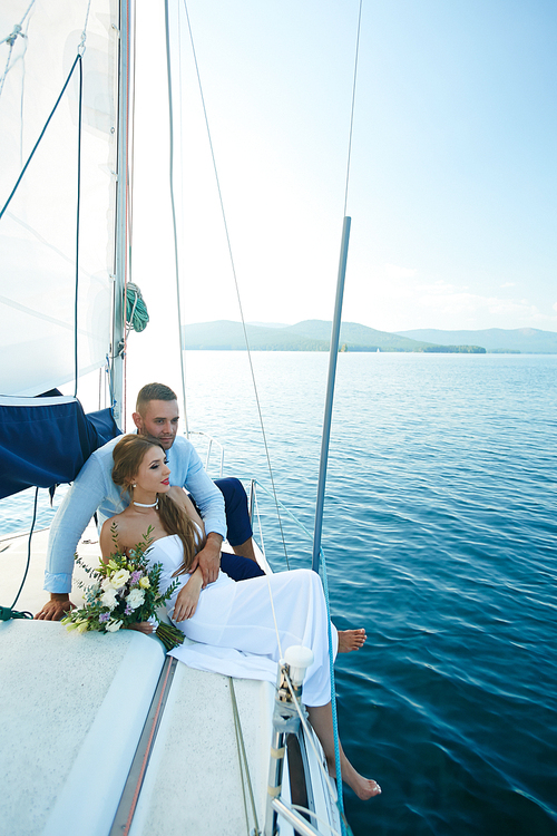 Young newlyweds traveling by yacht during voyage