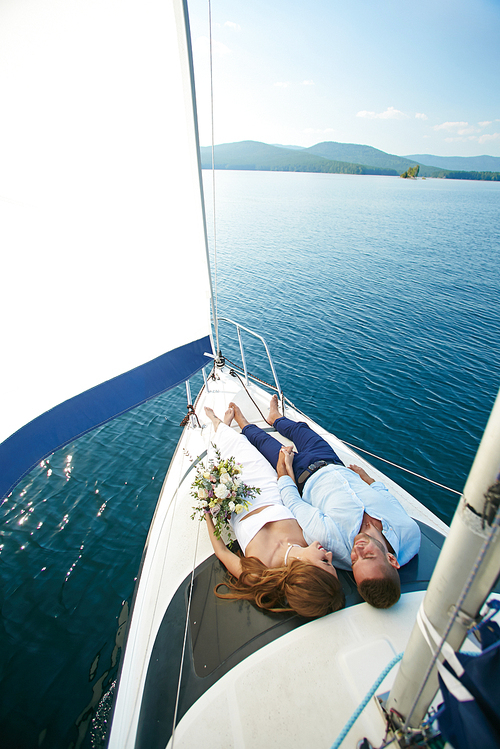 Relaxed man and woman floating by yacht