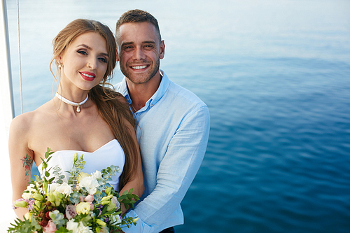 Amorous husband and wife enjoying honeymoon cruise