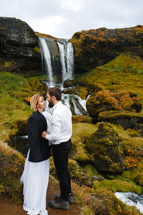 Young couple flirting on background of waterfall