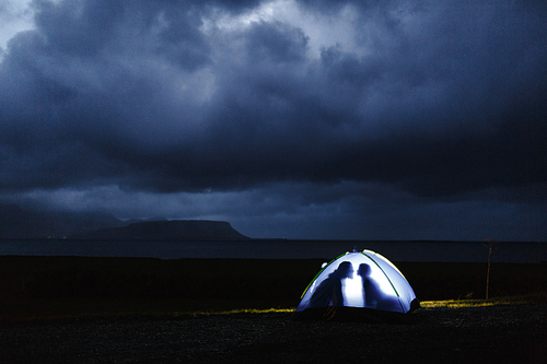 Human outlines in tent on stormy night