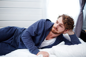 Sad man lying in bed during sleepless night