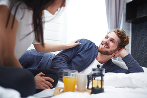 Happy man looking at his wife while talking to her