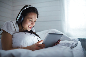 Girl with headphones looking in touchpad