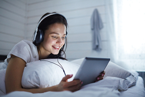 Girl with modern gadget watching something interesting online