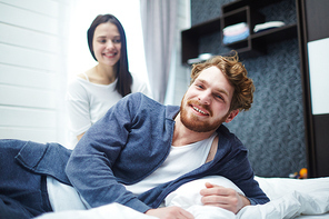 Cheerful man and his wife enjoying home rest