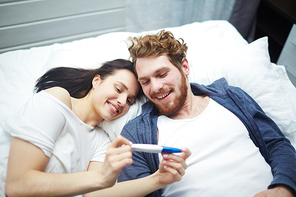 Married couple looking at positive pregnancy-test