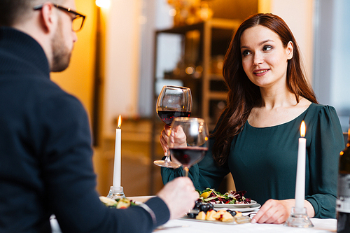 Young couple drinking red wine and eating salad in restaurant