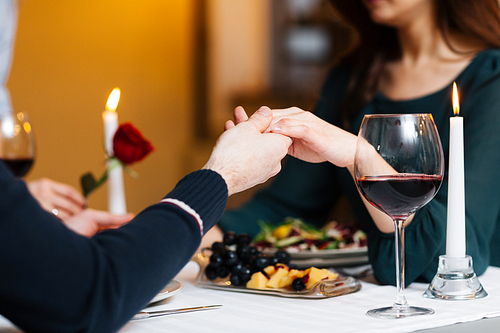 Hands of man and woman during romantic dinner
