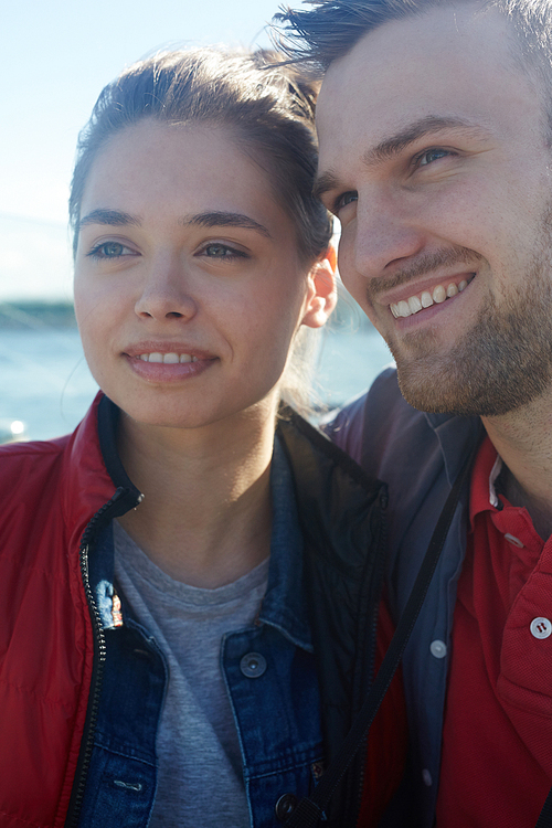 Cheerful guy and girl enjoying their seaside adventure at summer resort
