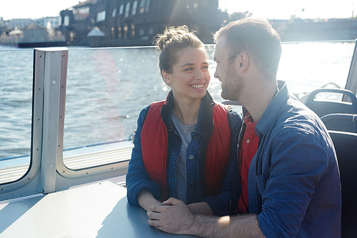 Young couple enjoying sunny day on motorship board during summer vacation
