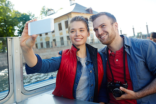 Affectionate lovers making selfie during cruise adventure