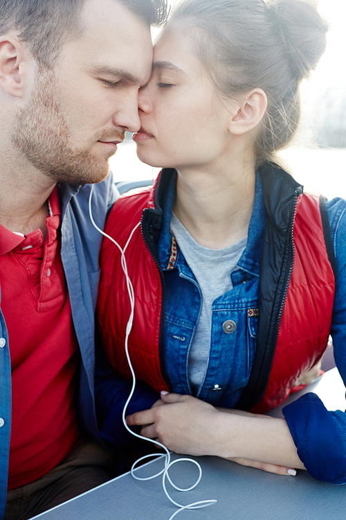 Amorous couple with earphones listening to romantic music on travel